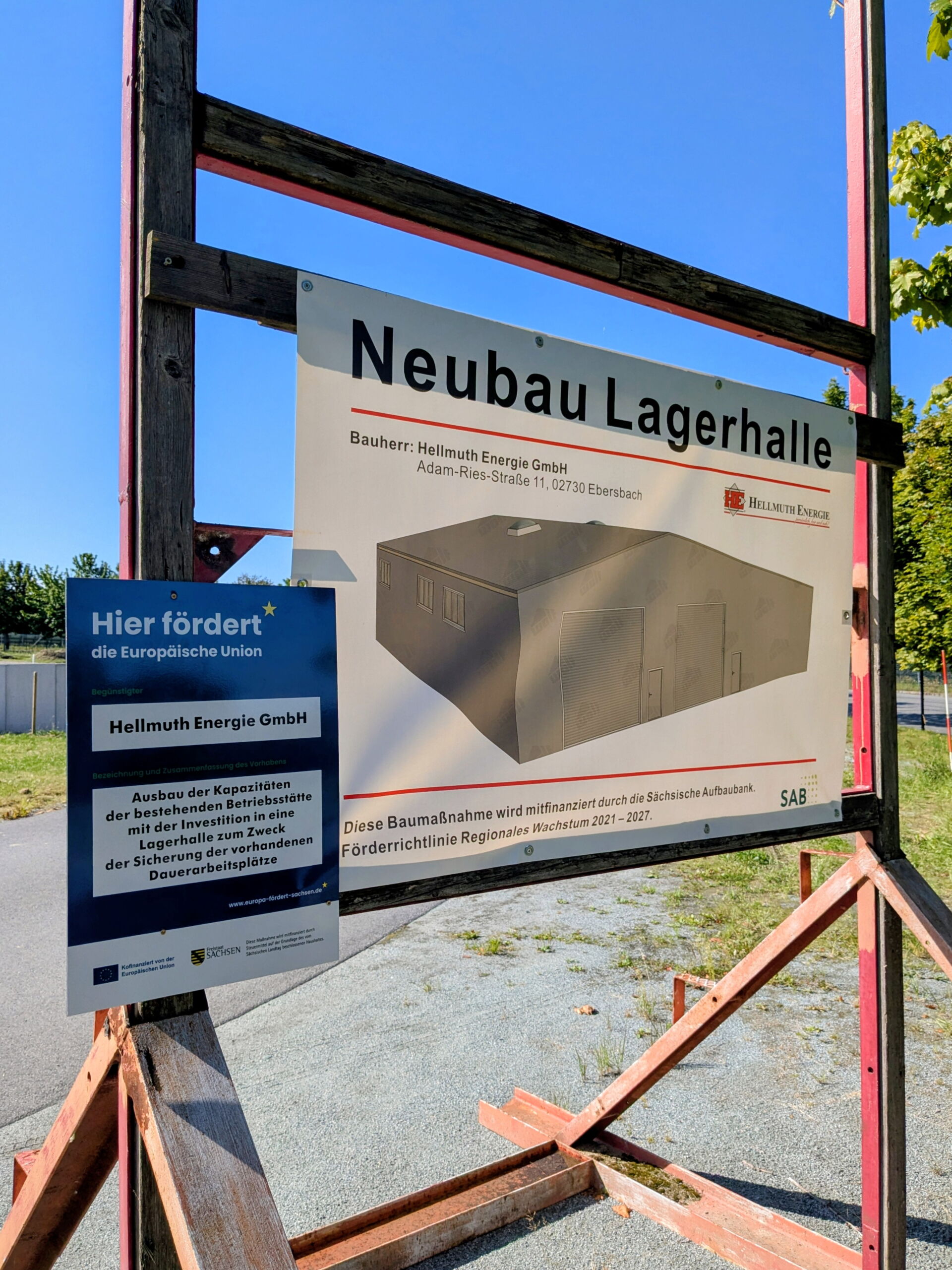 Baustellenschild zum Neubau der Lagerhalle mit Grafik der neuen Halle & Hinweis zur Förderung durch die Europäische Union